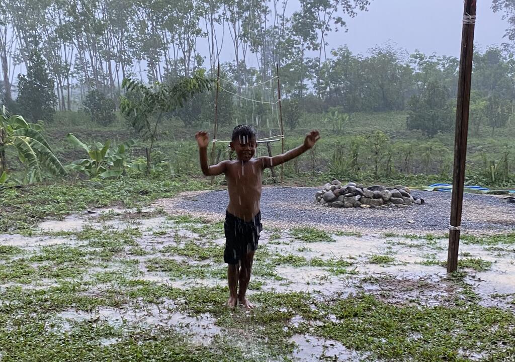Kids and visitors playing in the garden rain at Suan Tae Raek